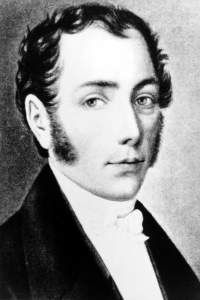 Black and white portrait of a man in profile with long sideburns, looking to his right