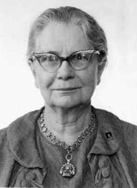 Black and white photo of a woman with glasses and her hair tied back
