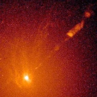 A very luminous yellow spot at the lower left emitting a luminous light beam diagonally, surrounded by a cloud of yellow, orange and red dots