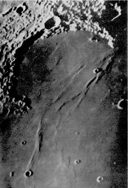 Photographie en noir et blanc d'une surface texturée contenant des élévations et des trous sphériques