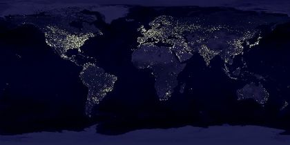 Satellite image of the Earth at night with numerous luminous dots, particularly in the northern hemisphere
