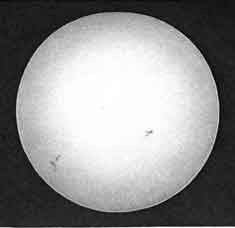 Daguerréotype représentant une sphère blanche tachetée de gris sur le pourtour sur un fond noir
