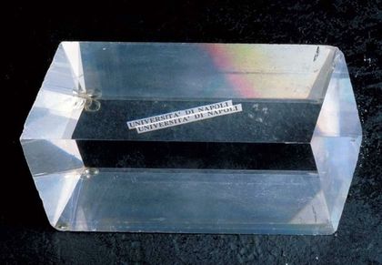 Photo d'un prisme rectangulaire transparent de calcite d'Islande sur un fond noir